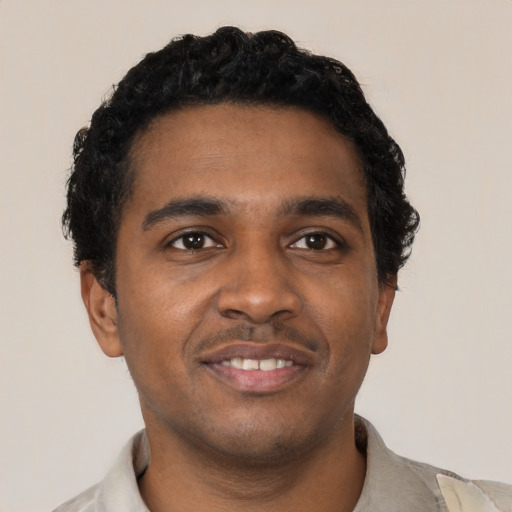 Joyful black young-adult male with short  black hair and brown eyes