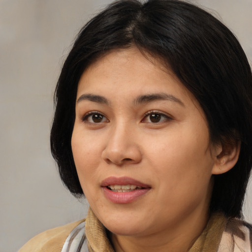 Joyful latino adult female with medium  brown hair and brown eyes