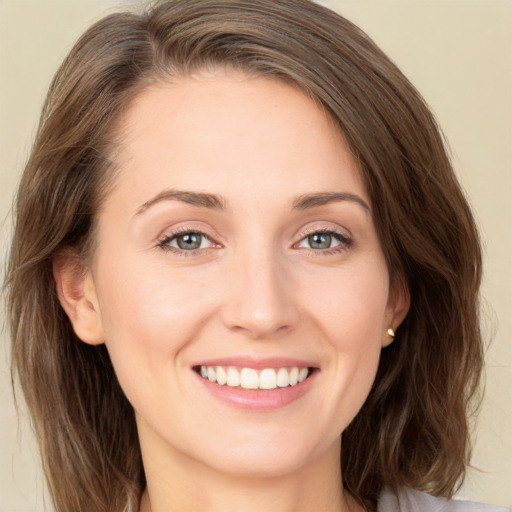 Joyful white young-adult female with medium  brown hair and green eyes