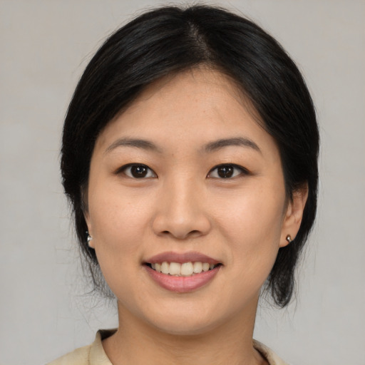 Joyful asian young-adult female with medium  black hair and brown eyes
