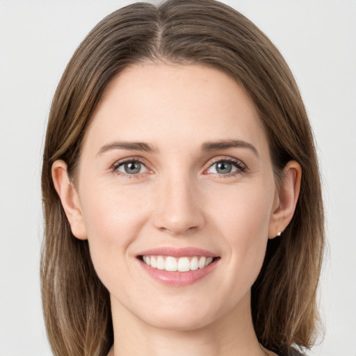 Joyful white young-adult female with long  brown hair and grey eyes