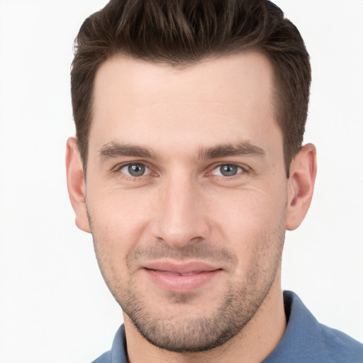 Joyful white young-adult male with short  brown hair and grey eyes