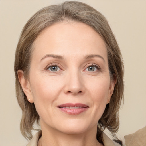 Joyful white adult female with medium  brown hair and grey eyes