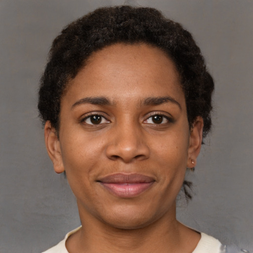 Joyful black young-adult female with short  brown hair and brown eyes