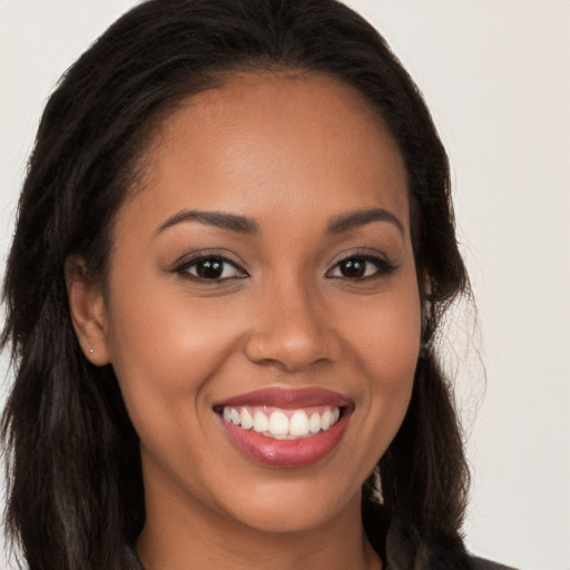 Joyful latino young-adult female with long  brown hair and brown eyes