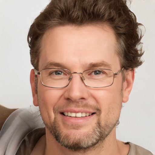 Joyful white adult male with short  brown hair and blue eyes