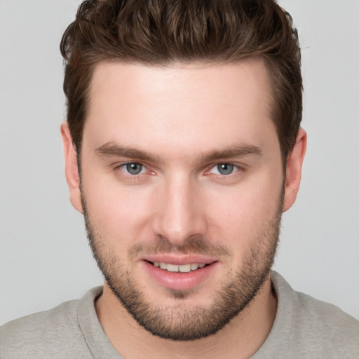 Joyful white young-adult male with short  brown hair and grey eyes