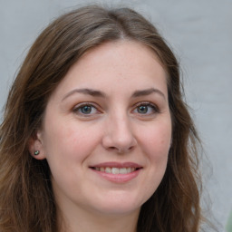 Joyful white young-adult female with long  brown hair and green eyes