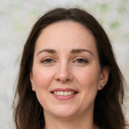 Joyful white adult female with long  brown hair and grey eyes