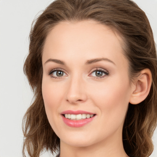 Joyful white young-adult female with long  brown hair and green eyes