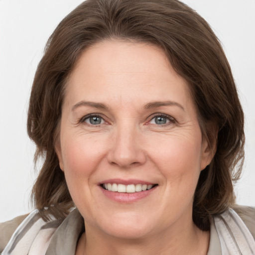 Joyful white adult female with medium  brown hair and grey eyes