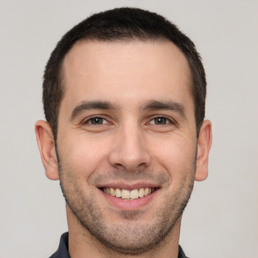 Joyful white young-adult male with short  brown hair and brown eyes