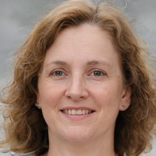 Joyful white adult female with medium  brown hair and blue eyes