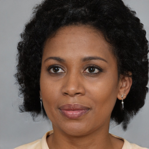 Joyful black adult female with medium  brown hair and brown eyes