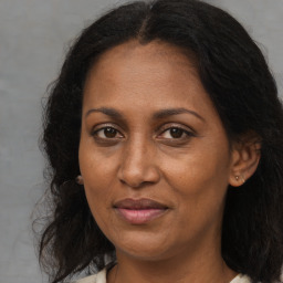 Joyful black adult female with long  brown hair and brown eyes