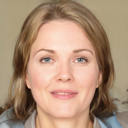 Joyful white adult female with medium  brown hair and blue eyes