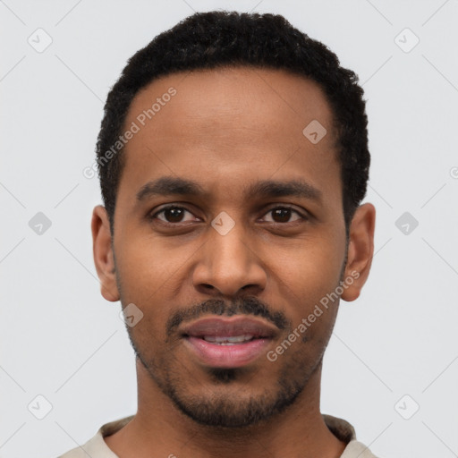 Joyful black young-adult male with short  black hair and brown eyes