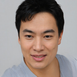 Joyful asian young-adult male with short  black hair and brown eyes