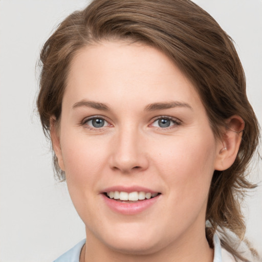 Joyful white young-adult female with medium  brown hair and grey eyes