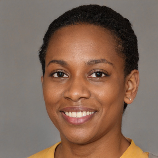 Joyful black young-adult female with short  black hair and brown eyes