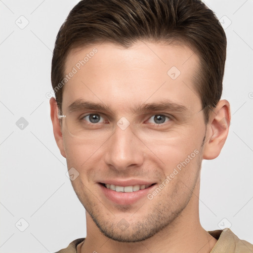 Joyful white young-adult male with short  brown hair and grey eyes