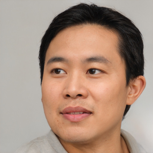Joyful asian young-adult male with short  brown hair and brown eyes