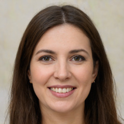 Joyful white young-adult female with long  brown hair and grey eyes