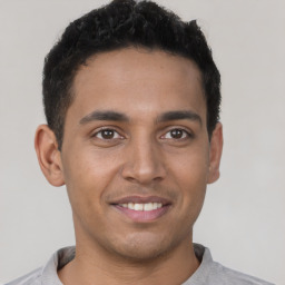 Joyful latino young-adult male with short  brown hair and brown eyes