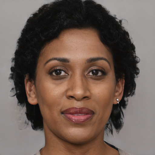 Joyful black adult female with short  brown hair and brown eyes