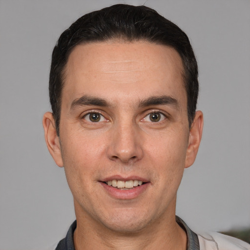 Joyful white adult male with short  brown hair and brown eyes