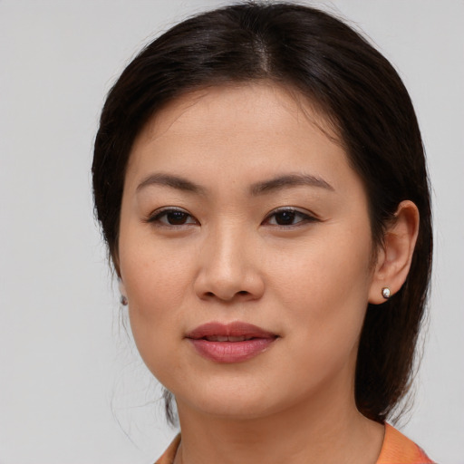 Joyful asian young-adult female with medium  brown hair and brown eyes
