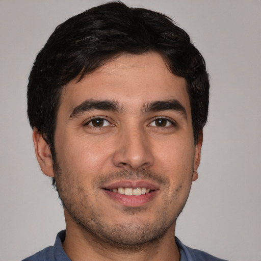Joyful white young-adult male with short  black hair and brown eyes