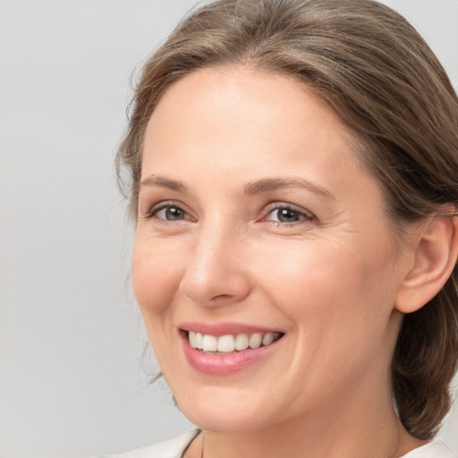 Joyful white adult female with medium  brown hair and brown eyes