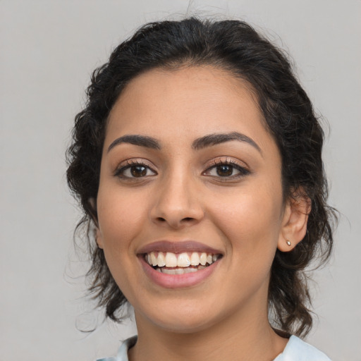 Joyful latino young-adult female with medium  brown hair and brown eyes