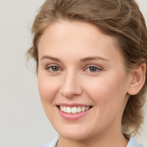 Joyful white young-adult female with medium  brown hair and green eyes