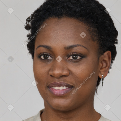 Joyful black young-adult female with short  brown hair and brown eyes