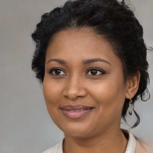 Joyful black young-adult female with medium  black hair and brown eyes