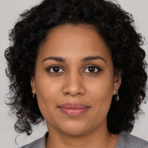 Joyful black young-adult female with medium  brown hair and brown eyes