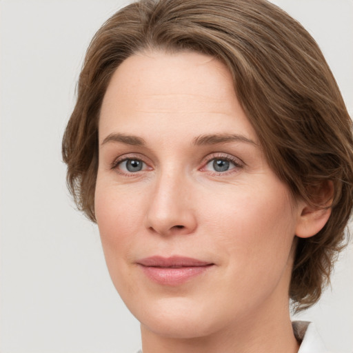 Joyful white young-adult female with medium  brown hair and green eyes