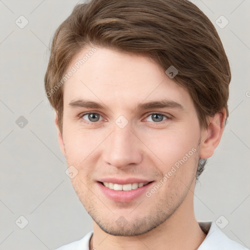 Joyful white young-adult male with short  brown hair and grey eyes