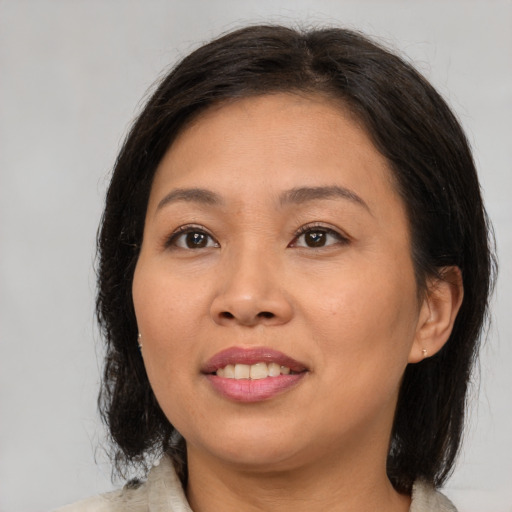 Joyful asian adult female with medium  brown hair and brown eyes