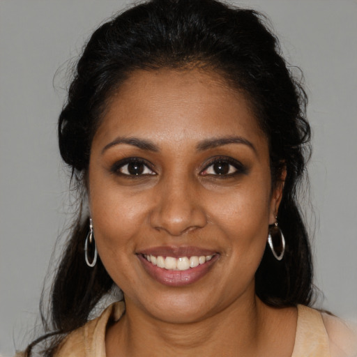 Joyful black young-adult female with long  brown hair and brown eyes