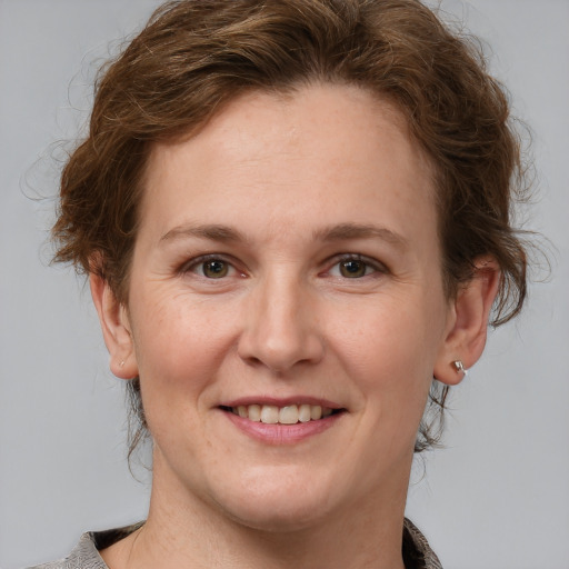 Joyful white adult female with medium  brown hair and grey eyes