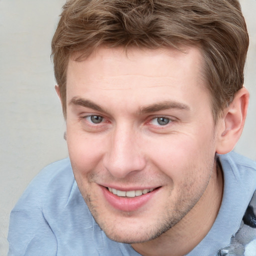 Joyful white young-adult male with short  brown hair and blue eyes