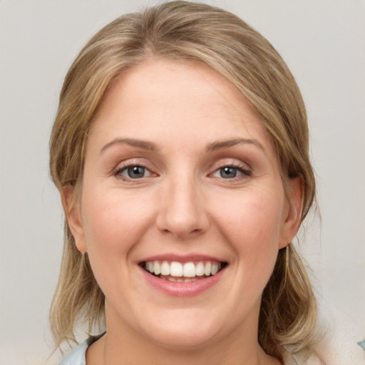 Joyful white young-adult female with medium  brown hair and blue eyes