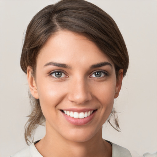 Joyful white young-adult female with medium  brown hair and grey eyes