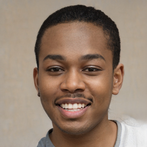 Joyful black young-adult male with short  black hair and brown eyes