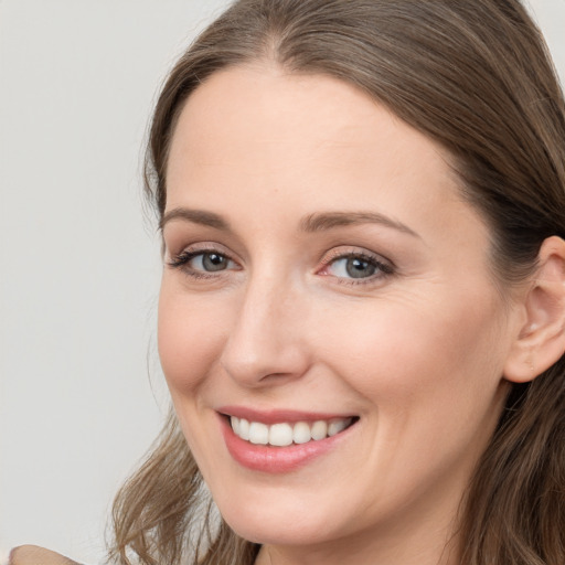 Joyful white young-adult female with long  brown hair and grey eyes