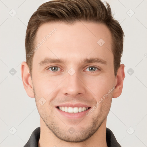 Joyful white young-adult male with short  brown hair and grey eyes