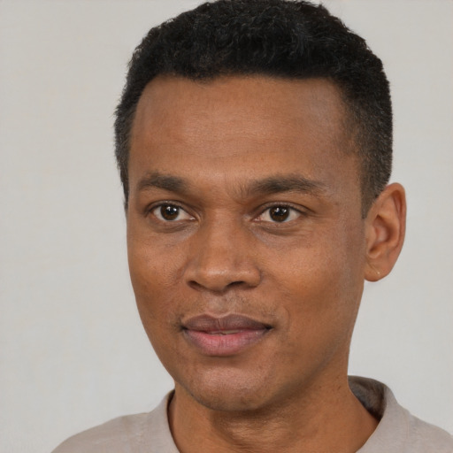 Joyful black young-adult male with short  black hair and brown eyes